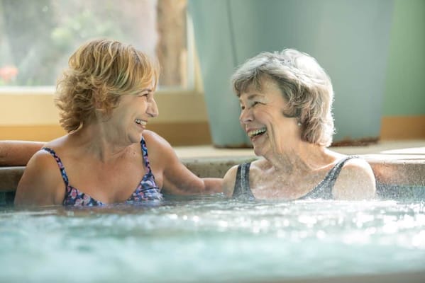 Two residents enjoying a spa in a warm atmosphere