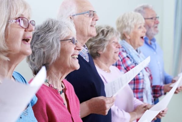 Seniors singing together in a cheerful group activity