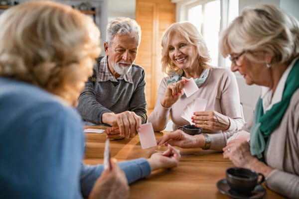 Seniors engaged in a card game around a table