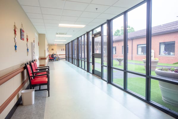 Bright interior hallway with outdoor view and seating