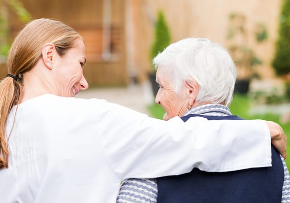 Caregiver with an elderly resident in a garden