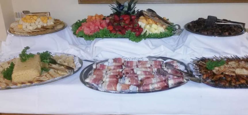 A buffet table with assorted food items and fruit platters