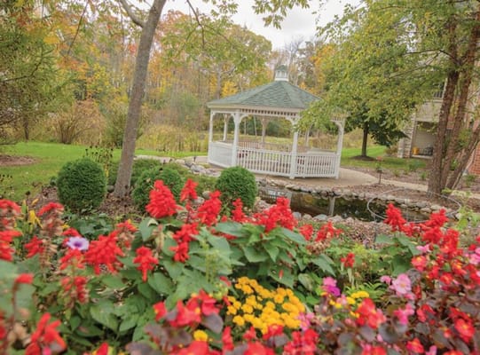 Gazebo surrounded by colorful flowers in a landscaped garden