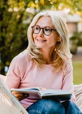 A woman reading a book in an outdoor setting