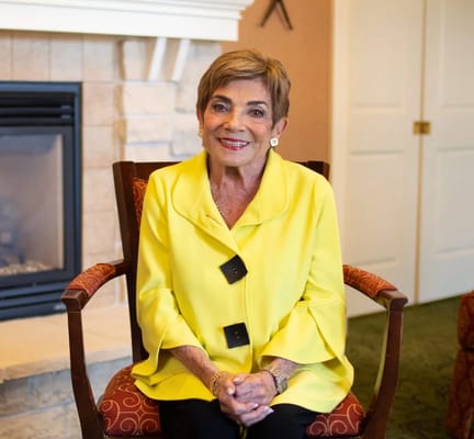 Resident smiling in a cozy lounge chair