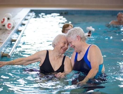 Two residents enjoying water therapy in a pool