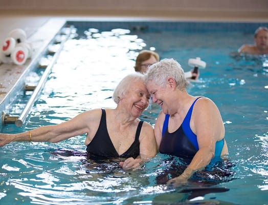 Residents enjoying a water aerobics session in a pool