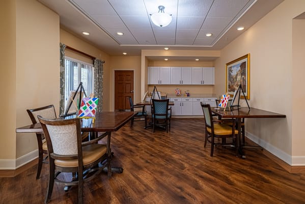 Bright common area with tables and chairs set up for activities