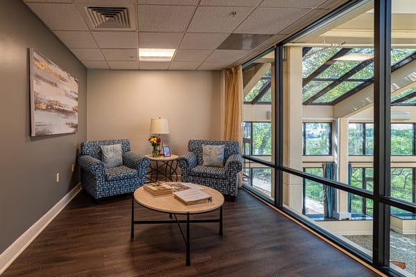 Bright common area with comfortable seating and greenery outside