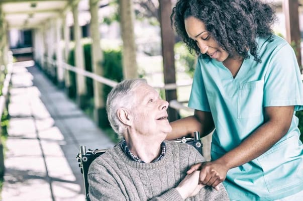 A caregiver assisting a resident in a hallway