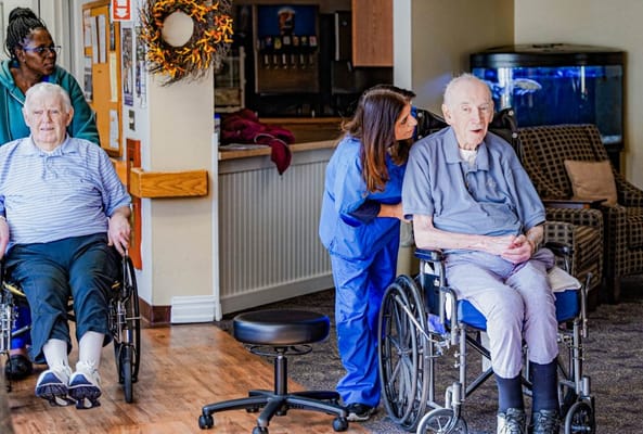 Residents interacting with a staff member in a common area