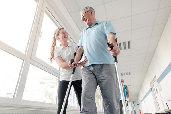 A staff member assisting a resident with walking equipment