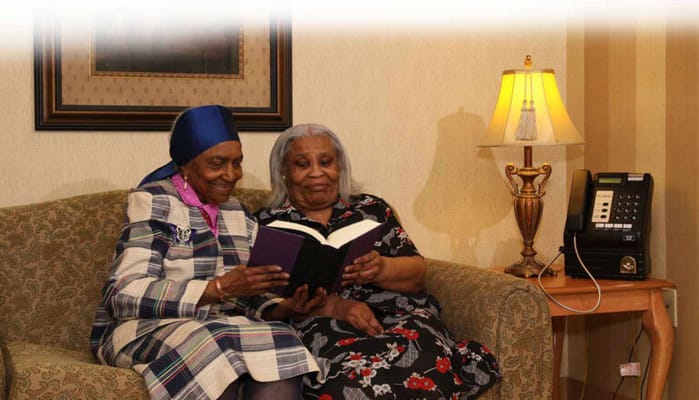 Two women reading together in a cozy living room