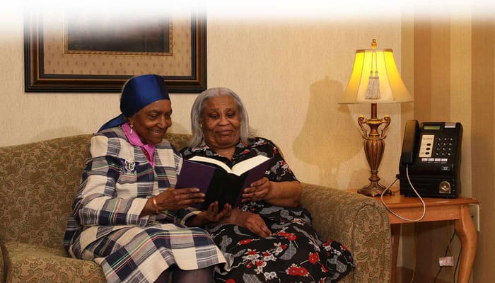 Two women reading together in a cozy living room