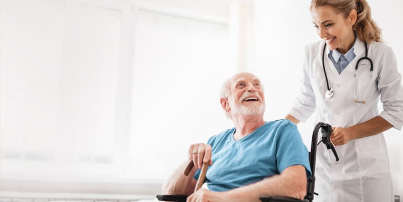 Healthcare professional assisting a smiling senior in a bright room