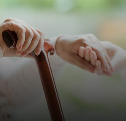 Close-up of hands with a cane showing support