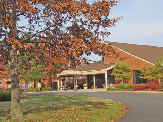 Exterior view of a senior living facility with autumn foliage