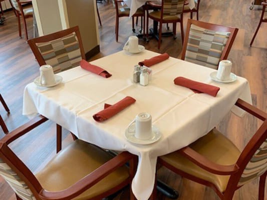 Dining table set for a meal with utensils and cups