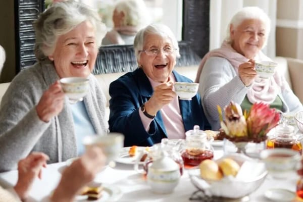 Residents enjoying tea and snacks in a cozy dining area
