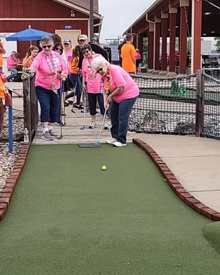 Residents participating in a mini-golf activity outdoors