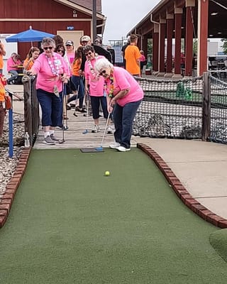 Residents participating in a mini-golf activity outdoors