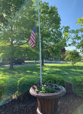 Flower pot in front of a flagpole with an American flag