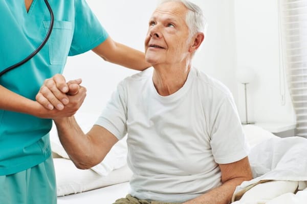 Caregiver assisting a senior in a bedroom setting
