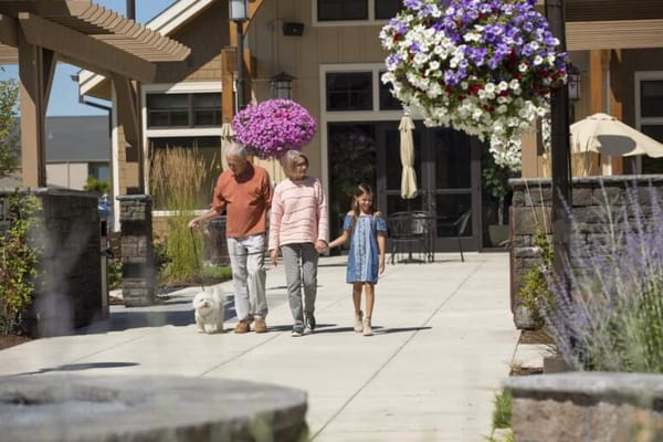 Elderly couple walking with a child and dog in the garden