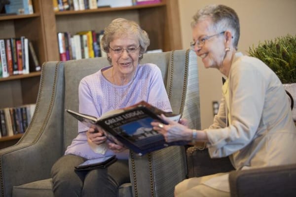 Two women enjoying a book in a cozy common area