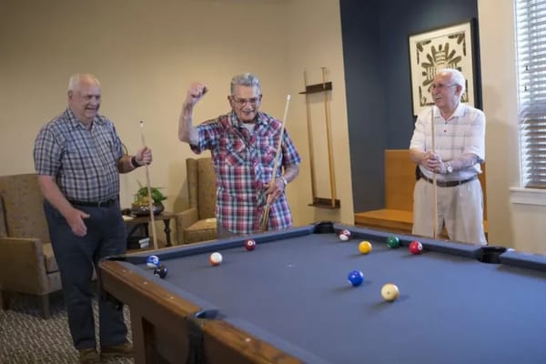 Residents enjoying a game of billiards in the common area