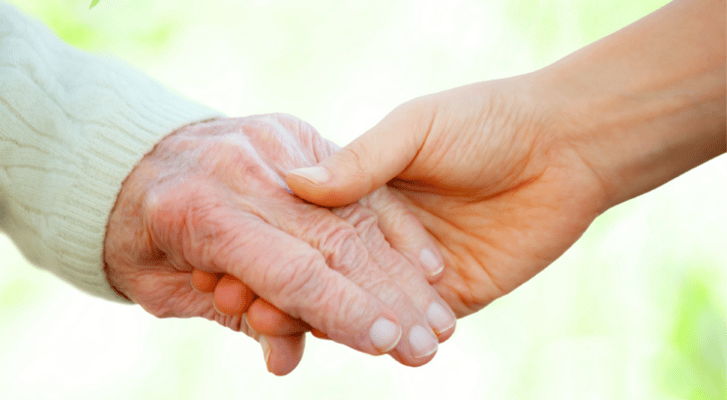 Close-up of an elderly hand being held