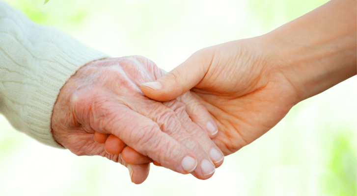 Close-up of an elderly hand being held