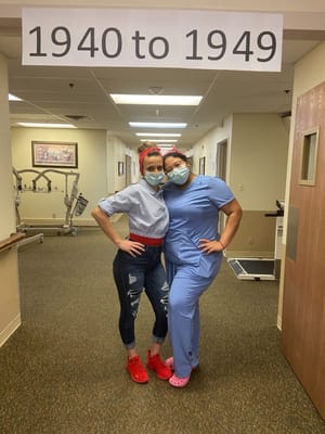 Two staff members posing in a hallway