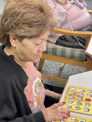 Resident playing bingo in a common area