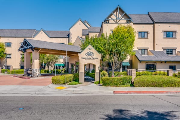 Main entrance of a senior living facility with gardens