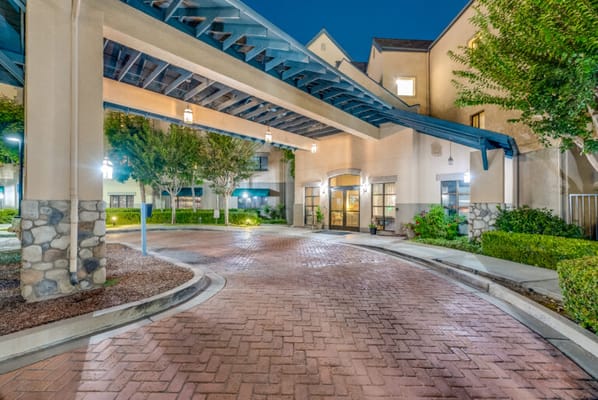 Entrance of a senior living facility with landscaped gardens