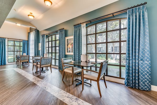 Bright common area with tables and large windows