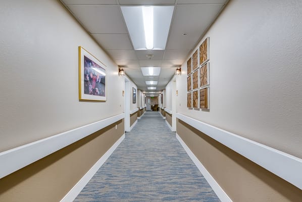 Well-lit hallway decorated with artwork