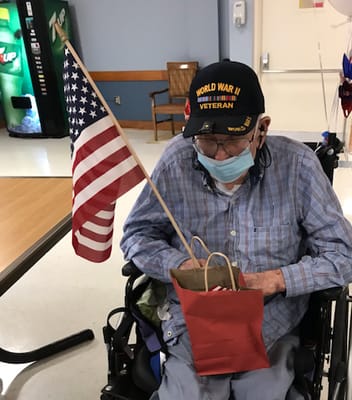 A veteran holding an American flag in a nursing home
