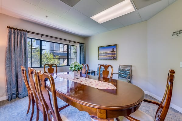 Brightly lit dining area with wooden table and chairs