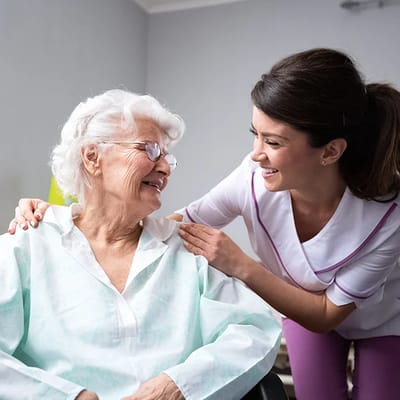 A caregiver interacting with a smiling resident