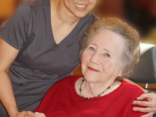 Caregiver smiling with a resident in a cozy setting