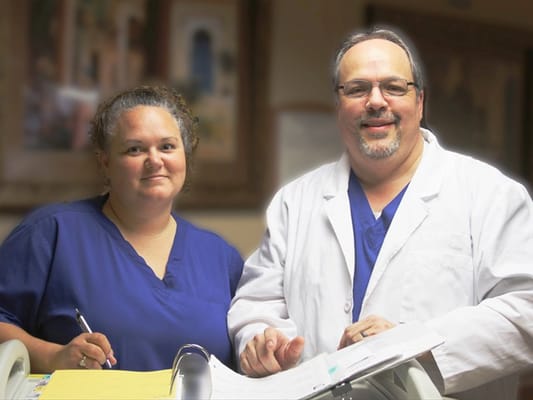 Two staff members in scrubs smiling in a facility