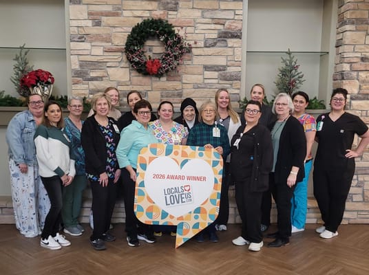 Staff members celebrating an award in a facility lobby