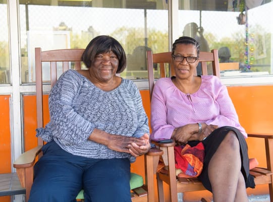 Two residents smiling while sitting outside