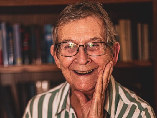 Elderly man smiling in a cozy indoor setting
