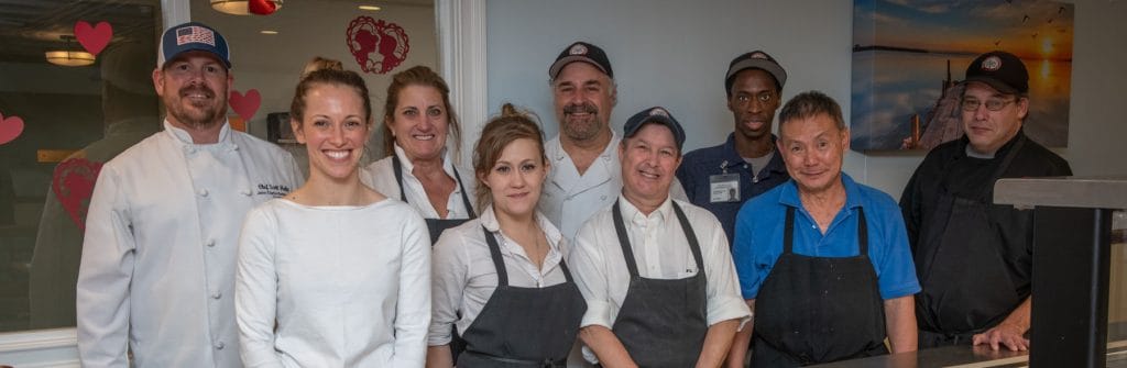 Staff members posing together in the kitchen area