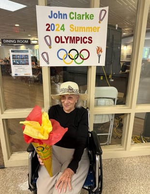 Resident participating in a summer Olympics event in the dining room