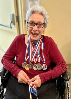 Resident proudly displaying medals and an American flag