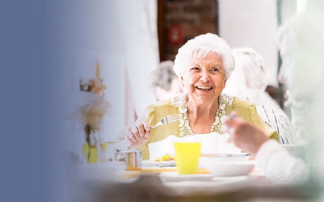 Resident enjoying a meal in a dining area